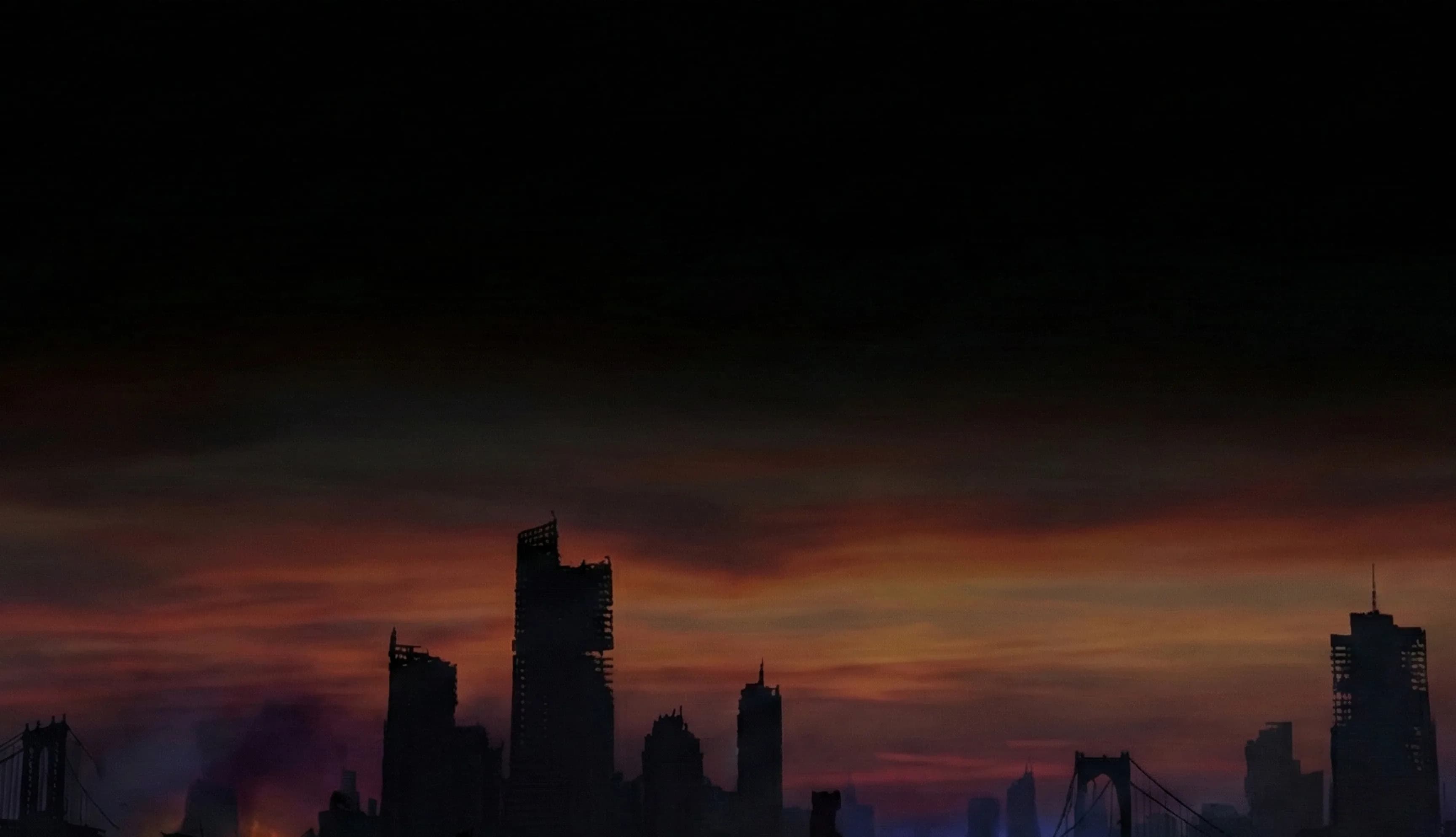 Dramatic city skyline silhouetted against vibrant sunset sky